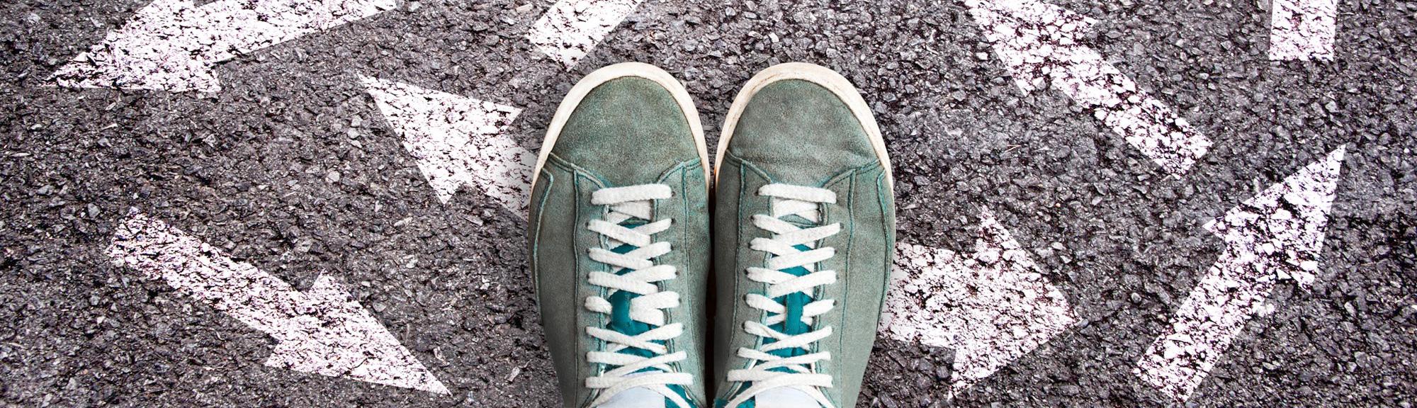 Ein paar Schuhe stehen auf einer Straße mit Pfeilen